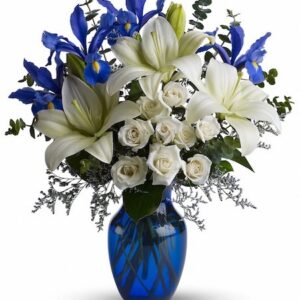 Blue glass vase with white lilies, white roses, and blue irises arranged fresh with green foliage for Cincinnati flower delivery.