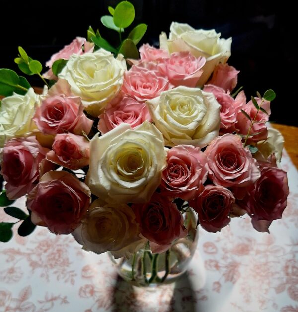 Handcrafted bouquet of white and blush‑pink roses with lush foliage, arranged in a clear vase and delivered fresh by a Cincinnati florist.