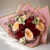 Luxurious mixed bouquet of roses, daisies, and seasonal accents wrapped in pink and gold paper