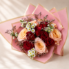 Luxurious mixed bouquet of roses, daisies, and seasonal accents wrapped in pink and gold paper