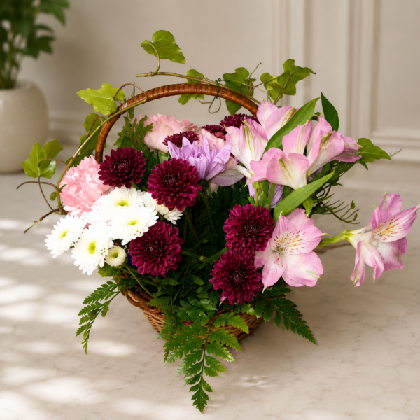 Garden Stroll Basket with roses, carnations, chrysanthemums, button poms, ivy, and fern leaves in a wicker handle arrangement.