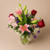 Lovely Lily bouquet with fresh pink lilies, red roses, and greenery arranged in a clear glass vase.