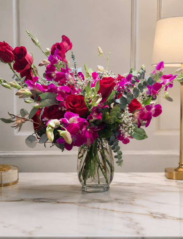 Luxury vase with red roses, dendrobium orchids, baby’s breath, and eucalyptus in clear glass.