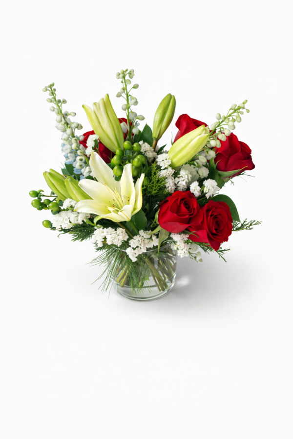Scarlet & Snow Scarlet & Snow vase with red roses, white lilies, filler flowers, green berries, and lush greenery in a clear glass vase.