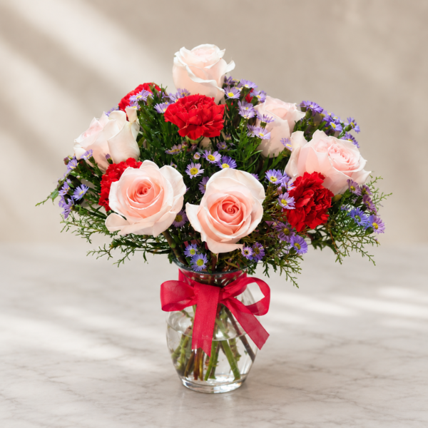 Soft Romance Flower Bouquet Fresh pink roses, red carnations, and purple daisies in a clear glass vase with a red ribbon, delivered fresh in Cincinnati and Northern Kentucky.