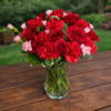 Como Tu No Hay bouquet of red roses, carnations, and pink blossoms in a clear vase on a wooden table, designed for weddings, events, and delivery in Cincinnati and Northern Kentucky.