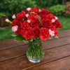 Como Tu No Hay bouquet of red roses, carnations, and pink blossoms in a clear vase on a wooden table, designed for weddings, events, and delivery in Cincinnati and Northern Kentucky.