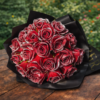 Vintage classic rose bouquet Vintage Classic Rose Bouquet with crimson petals and silver edges resting on a wooden table in a lush garden