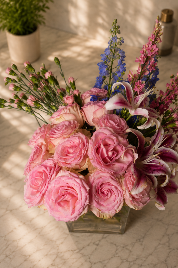 Liliana Smiles bouquet with pink roses, lilies, and accent blooms in a clear glass vase on marble surface, fresh floral arrangement for Cincinnati delivery