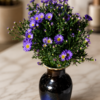 Something about Mary Fresh purple daisy bouquet with bright yellow centers arranged in a deep blue ceramic vase, styled on polished marble surface with soft natural background, elegant floral arrangement for secure Cincinnati delivery