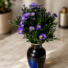 Something about Mary Fresh purple daisy bouquet with bright yellow centers arranged in a deep blue ceramic vase, styled on polished marble surface with soft natural background, elegant floral arrangement for secure Cincinnati delivery