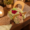 August in Ohio Bouquet with red roses, delicate buds, and lush greenery in a handcrafted arrangement on a wooden table.