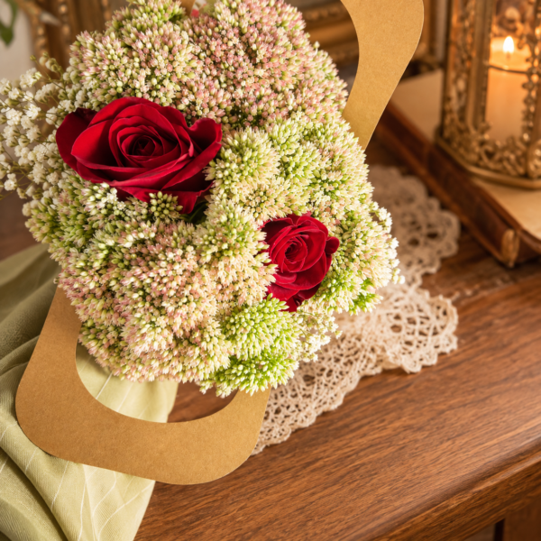 August in Ohio Bouquet with red roses, delicate buds, and lush greenery in a handcrafted arrangement on a wooden table.