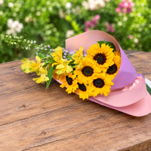 Cascading Sun bouquet featuring radiant sunflowers, lavender accents, and smaller yellow blooms, wrapped in pastel paper, handcrafted by allthepeoplesflowers.com for Cincinnati and Northern Kentucky delivery.