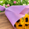 Cascading Sun bouquet featuring radiant sunflowers, lavender accents, and smaller yellow blooms, wrapped in pastel paper, handcrafted by allthepeoplesflowers.com for Cincinnati and Northern Kentucky delivery.
