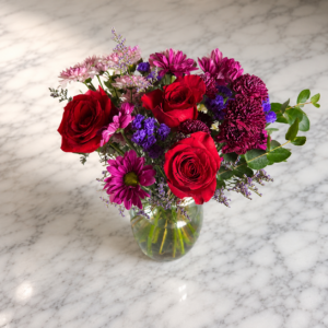 “She’s Royal (Eucalyptus Edition) bouquet featuring roses, chrysanthemums, magenta daisies, and eucalyptus in a handcrafted arrangement from allthepeoplesflowers.com.